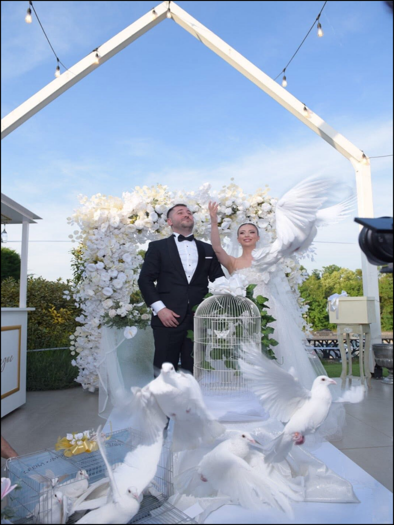 Бели гулаби кои летаат над младенците на свадба